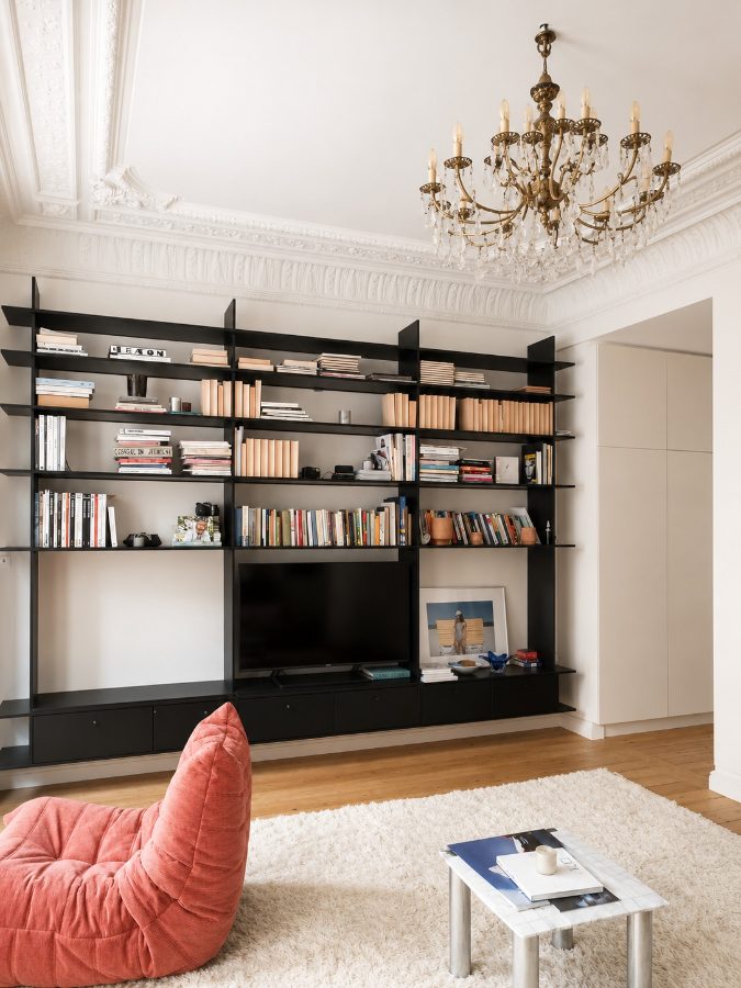 Leefruimte met boekenwand en gerestaureerd stucplafond