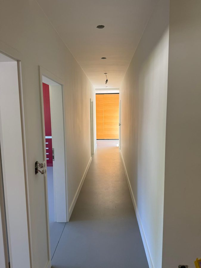 Vers geschilderde gang met strakke wanden en gietvloer