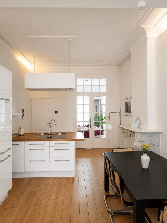 Gerenoveerd herenhuis-interieur met marmeren schouw en eettafel