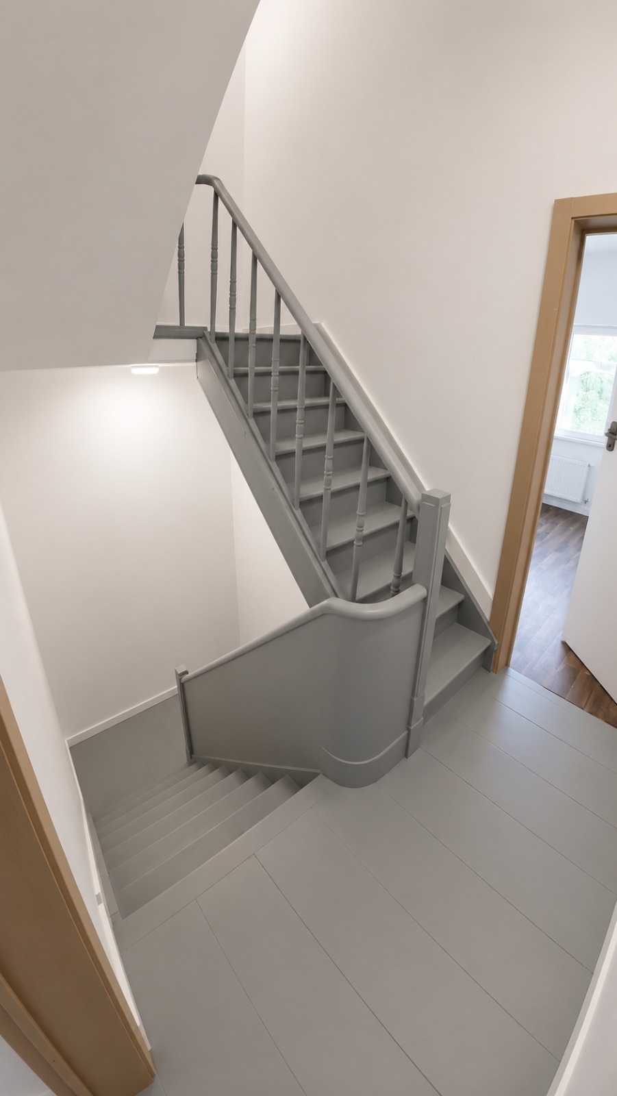 Gerenoveerde en grijs geschilderde houten trap