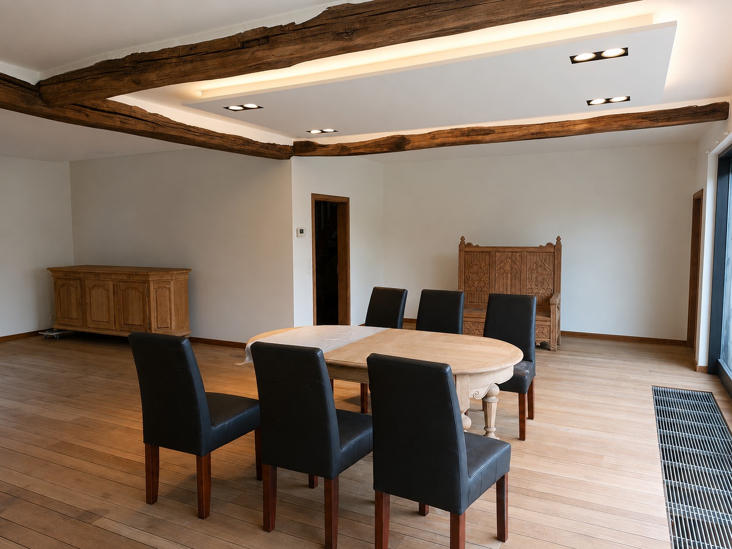 Eetkamer met gerestaureerde eiken balken en verlaagd plafond met indirecte verlichting